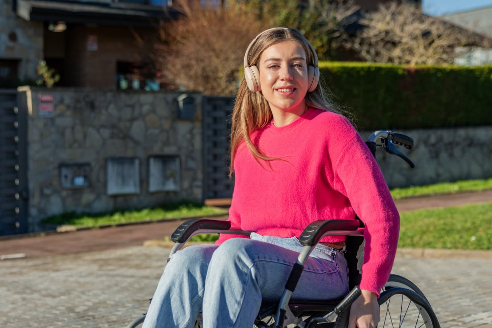 Mujer joven en silla de ruedas paseando por la calle