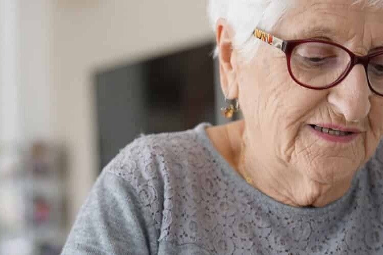 mujer mayor con gafas leyendo estimulacion cognitiva a domicilio