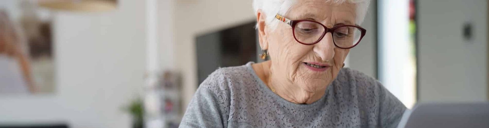 mujer mayor con gafas leyendo estimulacion cognitiva a domicilio
