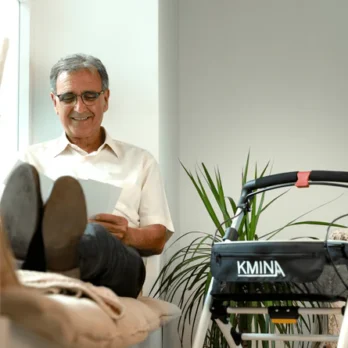 hombre mayor sentado en silla con ruedas tipo andador reversible