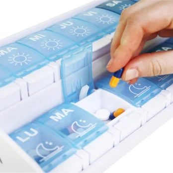mano abriendo compartimento de pastillero azul con etiquetas