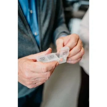 mano organizando un pastillero mensual con modulos azules