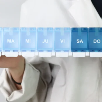 pastillero azul sostenido con ambas manos por una persona