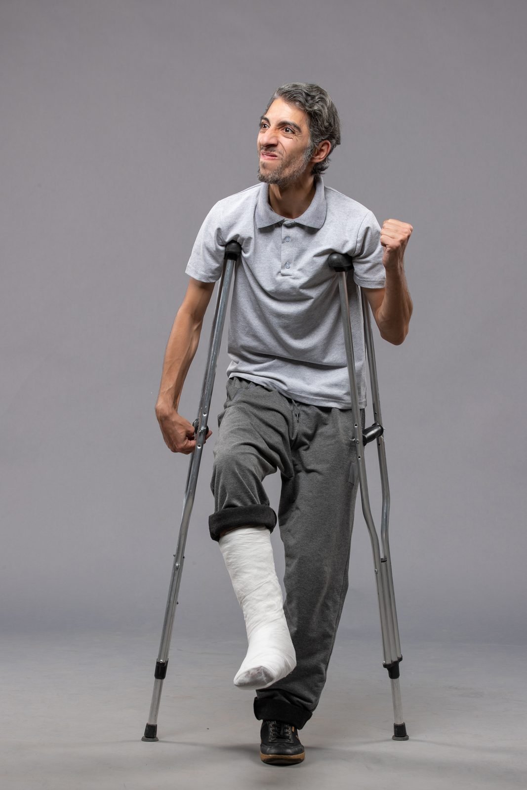 Hombre joven caminando con muletas